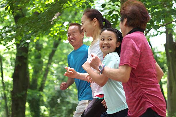 sonriendo familia juntos para trotar - family sport exercising jogging fotografías e imágenes de stock