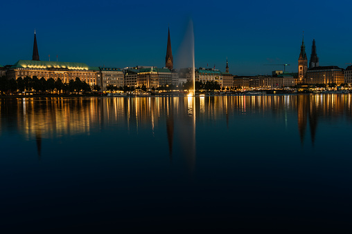 During blue hour view to Binnenalster with fountain in Hamburg,  Germany.