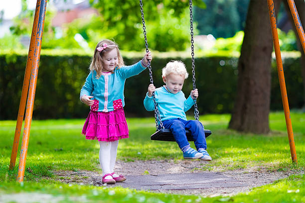 istock Kids on playground swing 482894312