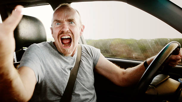 istock Road rage: furious male driver shouting, waving, and yelling 482896454