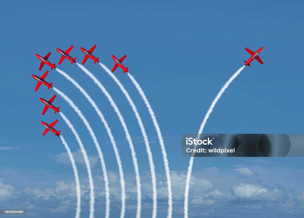 Independent Innovation Independent innovation and new thinking concept or leadership symbol of individuality as a group of flying jet airplanes with one individual airplane going in the opposite direction as a business icon for innovative thinker. Standing Out From The Crowd Stock Photo