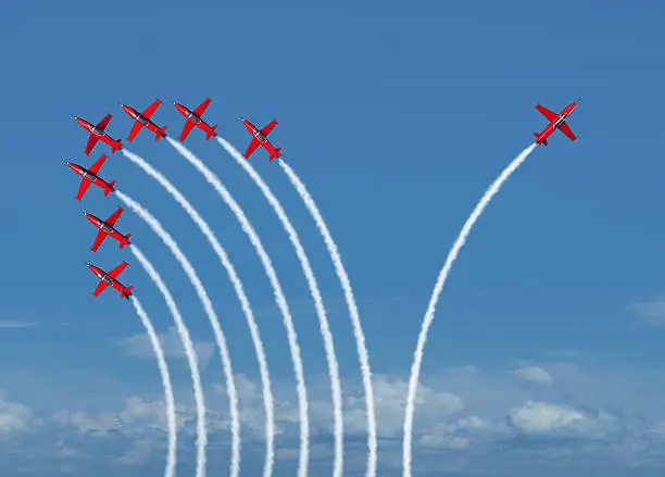 Independent innovation and new thinking concept or leadership symbol of individuality as a group of flying jet airplanes with one individual airplane going in the opposite direction as a business icon for innovative thinker.