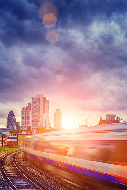 London Overground with skyscrapers in the background London Overground with the City of London skyscrapers  in the background (including The Gerkhin) commuter train photos stock pictures, royalty-free photos & images