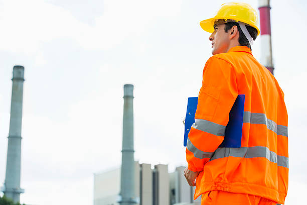 istock Back view of male architect with clipboard standing at site 482902451