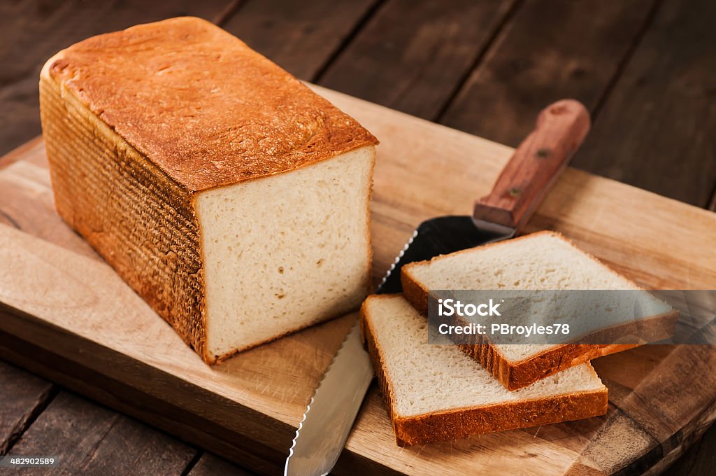 Barra de pan en tabla de cortar - Foto de stock de Al horno libre de derechos
