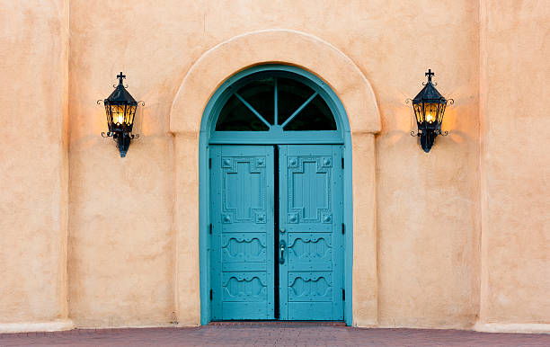 Double doors of San Felipe de Neri church in Albuquerque Blue, double doors of San Felipe de Neri church in Old Town, Albuquerque, New Mexico.  Iron lanterns on sides of adobe wall.  Building constructed in 1793 and listed on the National Register of Historic Places, America's official list of nation's historic places worthy of preservation. bernalillo county stock pictures, royalty-free photos & images