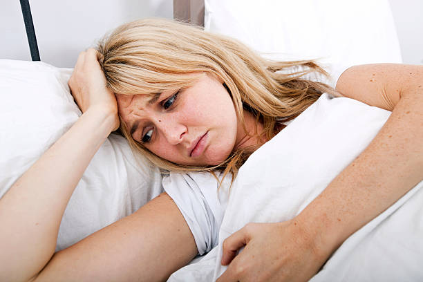 istock Young woman suffering from headache in bed 482905161