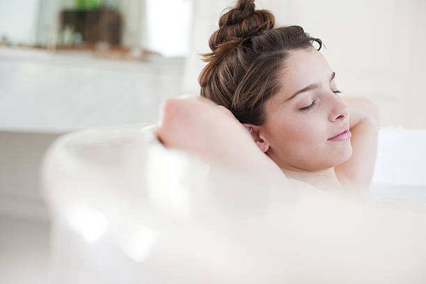 mulher relaxando no banho de espuma - bathtub women relaxation bathroom - fotografias e filmes do acervo