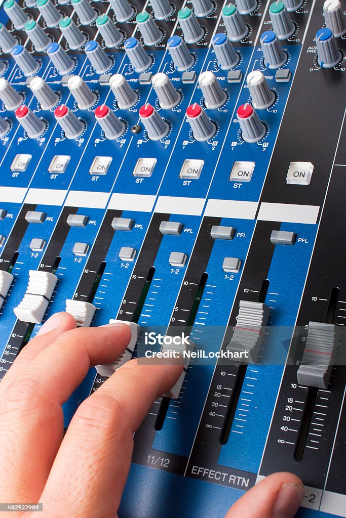 Mix di blu scheda faders e manopole a mano - Foto stock royalty-free di Apparecchiatura di registrazione del suono