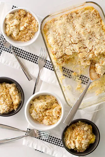 a photograph of a vintage recipe for a baked chicken breast casserole, featuring condensed soup, sour cream, poppy seeds, topped with breadcrumbs and Parmesan cheese and served in handmade ceramic bowls