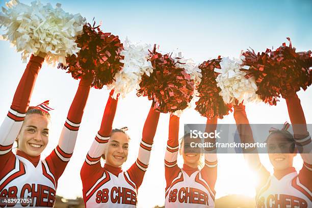 Happiness Cheerleaders Posing With Ponpon And Arm Raised Stock Photo - Download Image Now
