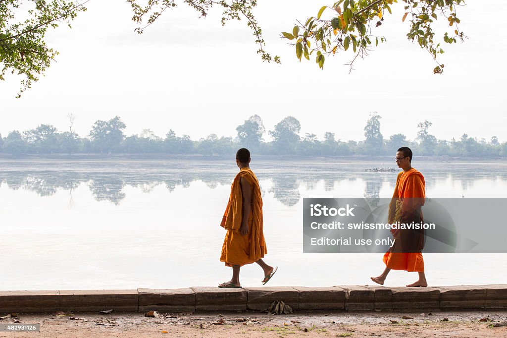 Two monks walking along the lake, Pre rup temple-Angkor-Cambodia Pre Rup temple, Angkor, Cambodia - May 21, 2015: Two monks walking along the lake, part of Pre rup temple. Monk - Religious Occupation Stock Photo