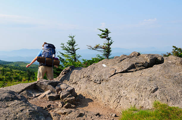 A young woman backpacks on the Appalachian Trail in southwest Virginia, part of a three-day hike that began in Grayson Highlands State Park at Elk Garden, on Highway 600. The white blaze is a trail marker indicating the path of the Appalachian Trail.
