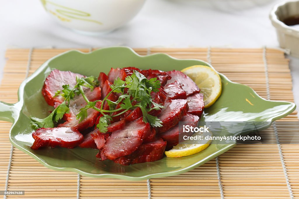 Dish of  chinese roast pork close up a dish of roast park on bamboo mat Char Siu Stock Photo