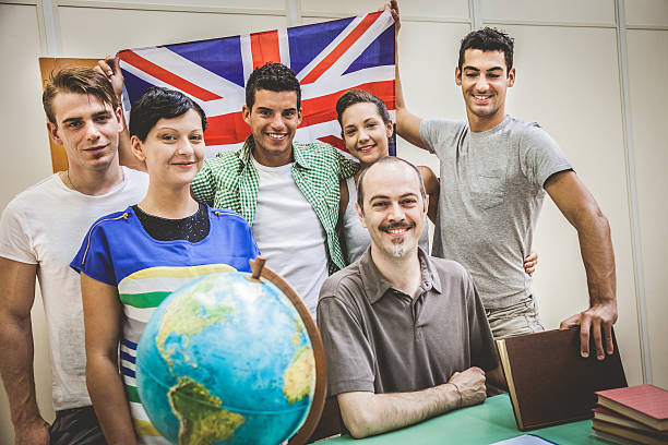 lächelnd studenten im klassenzimmer mit lehrer - adolescence flag university people stock-fotos und bilder