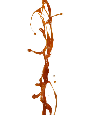 Caramel syrup splashing isolated on white background