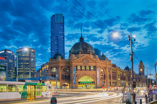 Melbourne, Australia - March 14, 2014: Flinders Street Station in Melbourne at night with a Melbourne tram in the foreground. Flinders Street Station is the busiest train station in Melbourne.