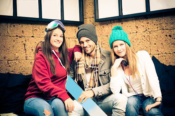 młody narciarzy siedzi na kanapie, - apres ski friendship skiing enjoyment zdjęcia i obrazy z banku zdjęć
