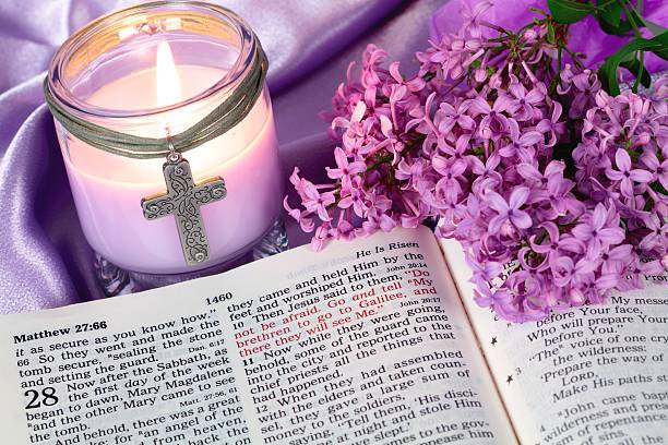 Holiday: Easter Bible Scripture with purple candle and flowers stock photo