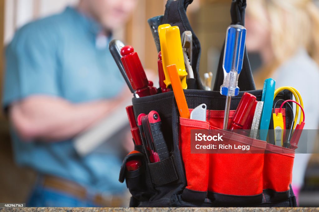 Home Repairman A repairman with tools standing in a kitchen. Craftsperson Stock Photo