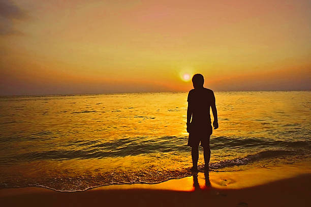 Man alone on beach stock photo