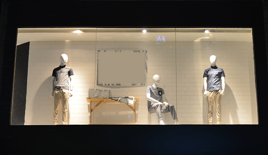Boutique display window with mannequins in fashionable dresses.