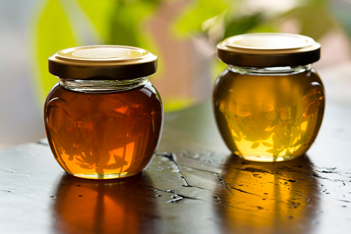 Glass jars full of honey, domestic room, Europe.