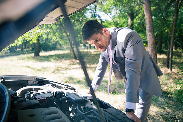 Man looking under the hood of car