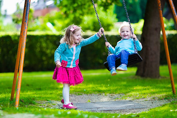istock Kids on playground swing 482978640