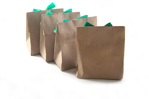 istock small gift wrapped in recycled paper with ribbon bow, isolated 482978956