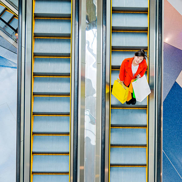 istock Female shopper standing on escalator 482982194