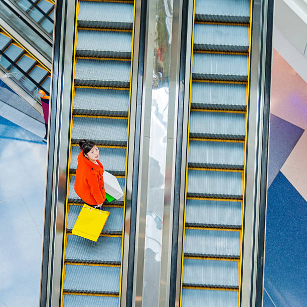 istock Female shopper standing on escalator 482982198
