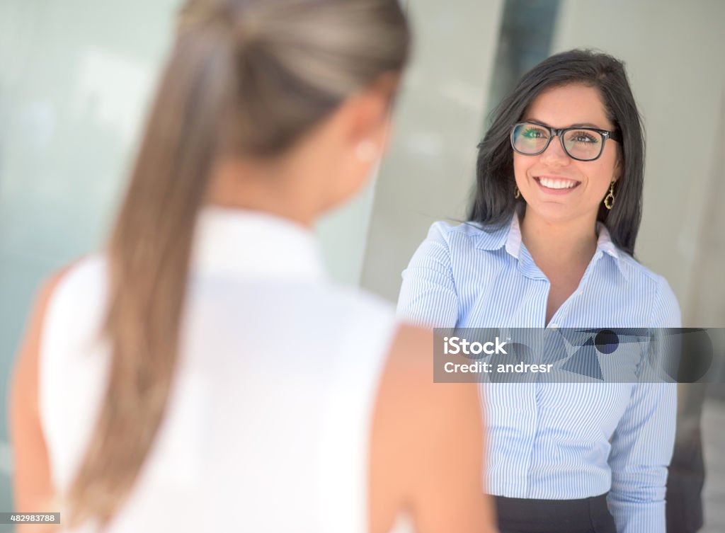 Business woman greeting with a handshake Successful business woman greeting a person with a handshake at the office Financial Advisor Stock Photo