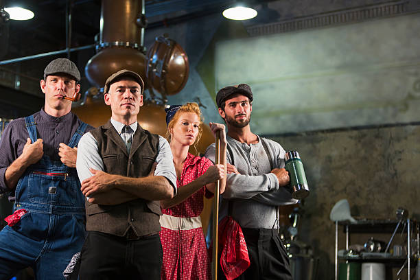Workers in an old distillery Group of four workers standing in an old distillery, staring at the camera.  They are wearing retro-style clothing, standing in front of the factory equipment, looking tough and intimidating. 1930s style men image created 1920s old fashioned stock pictures, royalty-free photos & images