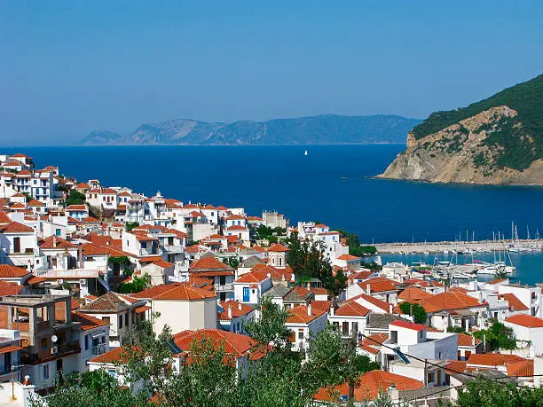 Sunny Skopelos town on background of Aegean sea. Skopelos island, Northern Sporades, Greece.