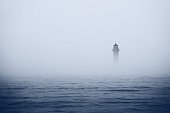 Lighthouse in foggy sea