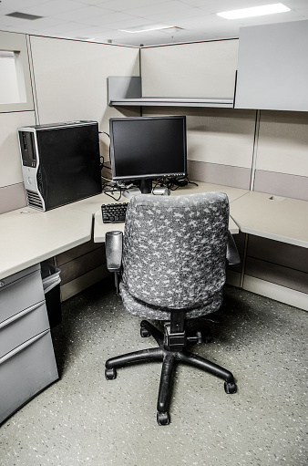 Empty office cubicle with chair and PC