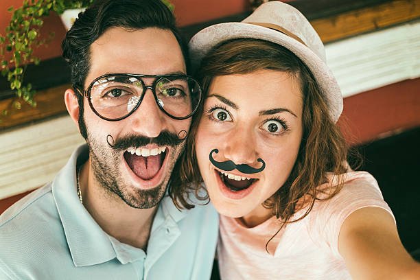 couple making selfie с mustaches - risible стоковые фото и изображения