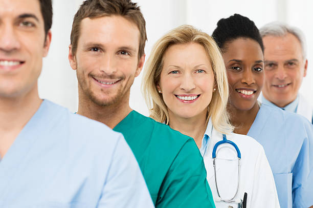 Group Of Happy Doctors Group Of Happy Successful Doctors Standing In A Row At Hospital people in a row photos stock pictures, royalty-free photos & images