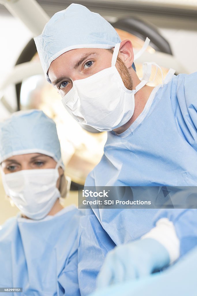 Fiducioso chirurgo preparazione per funzionare con il paziente in ospedale - Foto stock royalty-free di Adulto