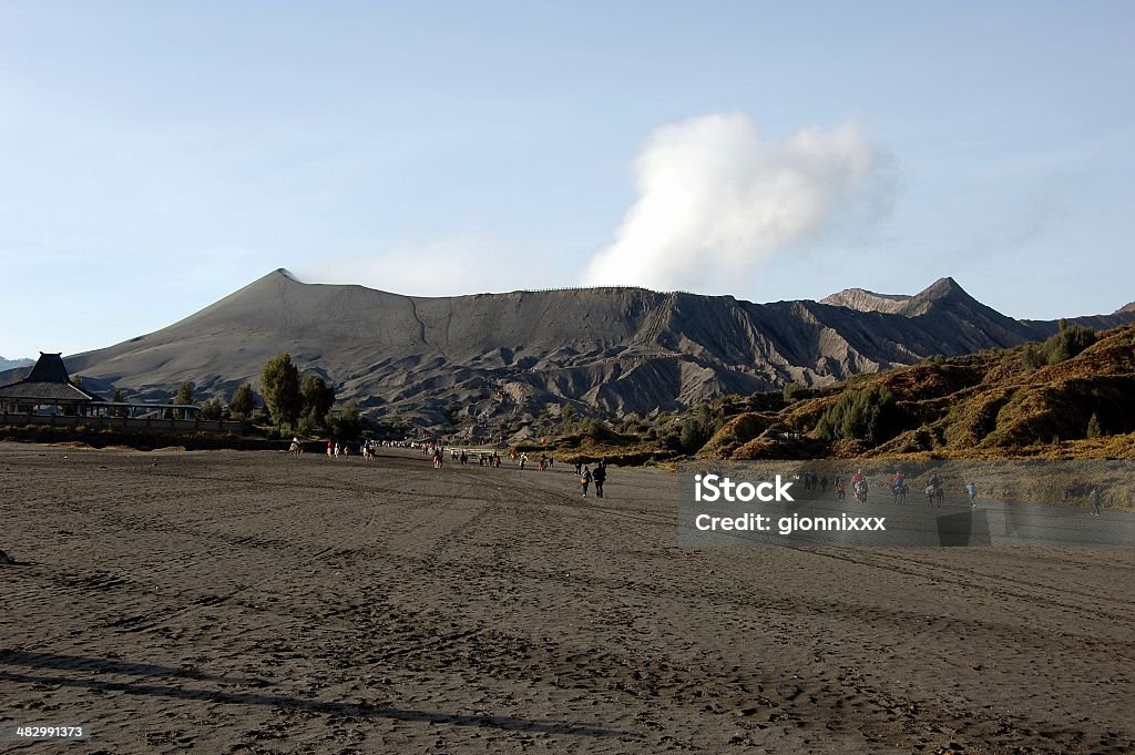 Mount Bromo and sea of black sand, East Java Background view of Mount Bromo active volcano,  part of the Tengger massif, in East Java. Active Volcano Stock Photo