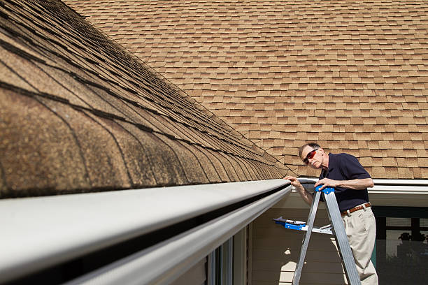 istock Home inspector examines a home's one piece seamless rain gutter 482992783