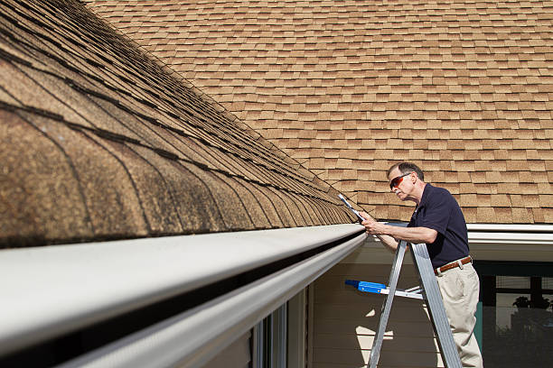 istock Home inspector examines a home's one piece seamless rain gutter. 482992799