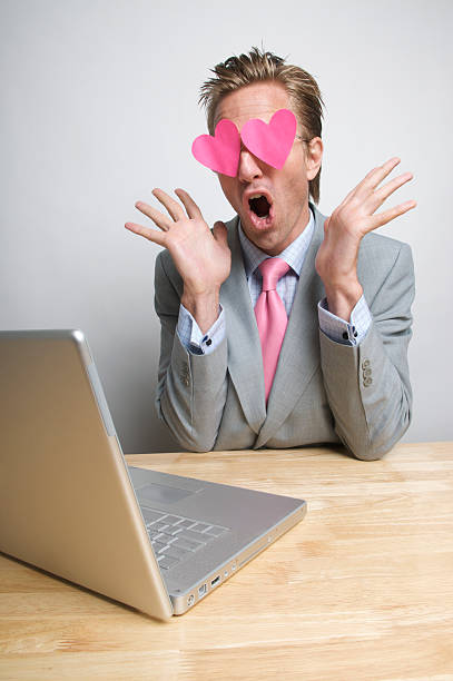 I Can't Believe My Eyes! Funny Businessman Looking at Laptop Funny businessman looking at his laptop computer with hearts in his eyes and an expression of complete surprise blind date stock pictures, royalty-free photos & images