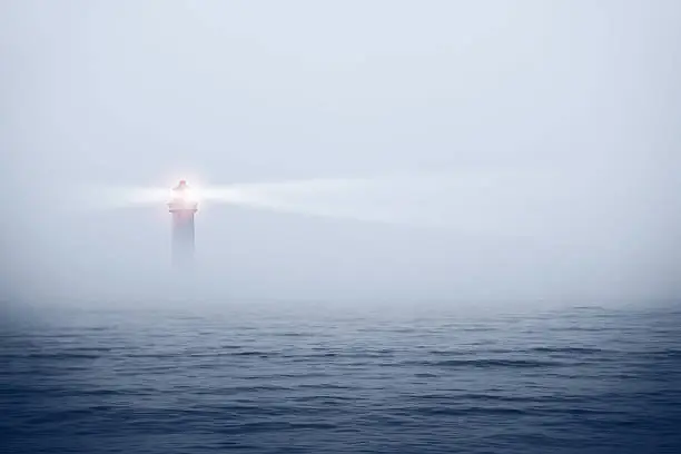 Photo of Lighthouse in a foggy sea