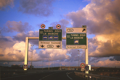 Calais, France - August 2, 2015: These are signs for the channel tunnel photographed from inside a car on a French Motorway near Calais in the Pas-De-Calais region of Northern France. It is shortly after sunrise and there are no people in the picture. 