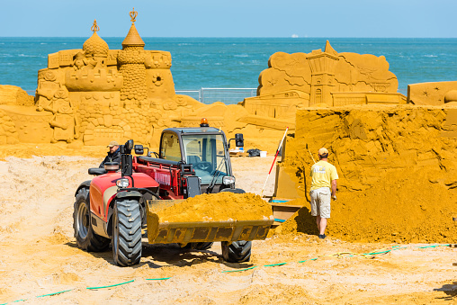 Ostend, Belgium - May 27, 2015: Sand Sculpture Festival «Frozen Summer Fun» 2015 at Ostend Beach, Belgium preparing. Curving artists are doing their job.