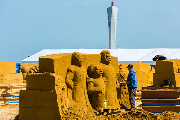 Ostend, Belgium - May 27, 2015: Sand Sculpture Festival «Frozen Summer Fun» 2015 at Ostend Beach, Belgium preparing. Curving artists are doing their job.