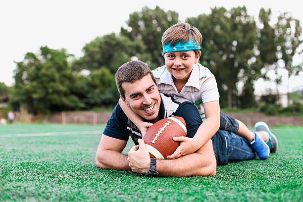 istock Father and son playing American football 483014132