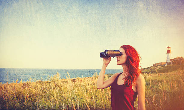 istock girl with binocular near Lighthouse 483014350